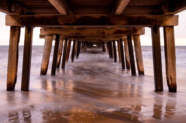 istock View under a jetty with a calm pink sea with low tides under a gloomy sky 1438573112