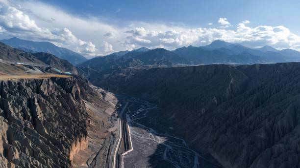 istock Road along the river going through mountains and cliffs, aerial 1438573650
