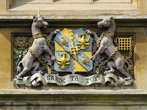 Cambridge, United Kingdom – August 11, 2017: CAMBRIDGE, UK:  Carved Coat of Arms of Magdalene College on outside of University College Building
