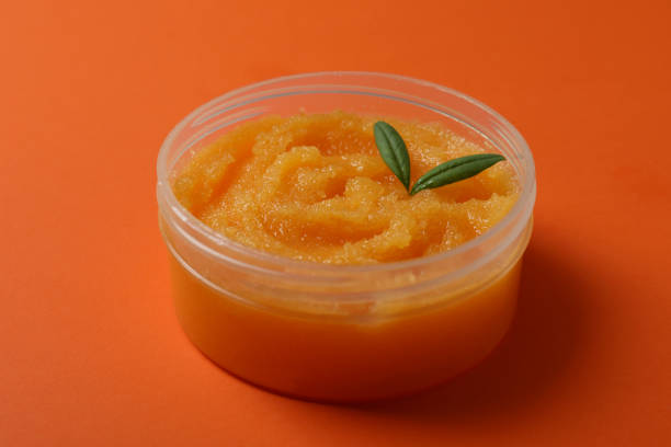 istock Cosmetic skin care scrub on orange background 1438575242