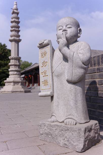 istock Vertical shot of an Asian statue holding a script of hieroglyphs 1438576639