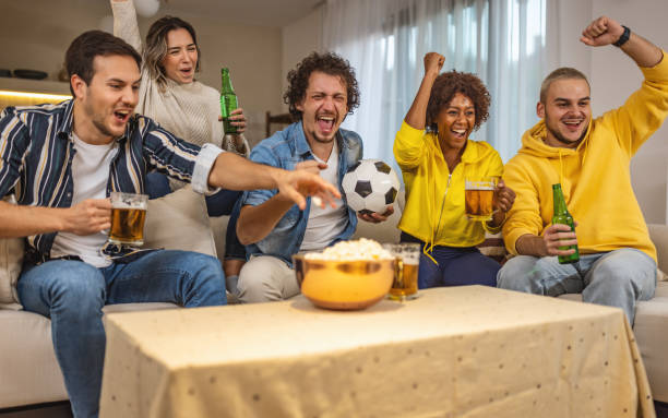 istock Soccer fans emotionally watching game at home. 1438577801