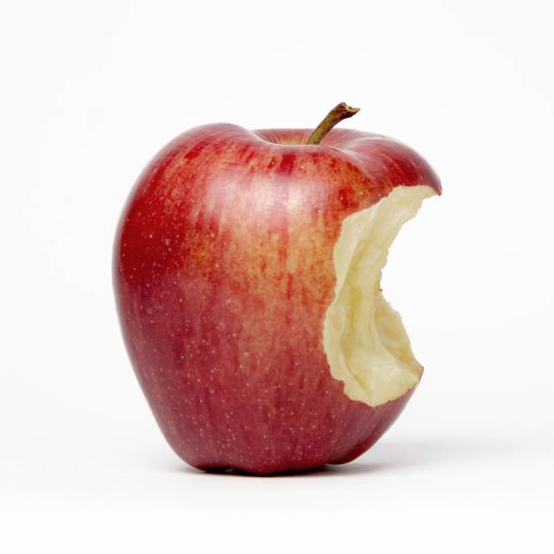 istock Closeup shot of a half-eaten apple on a white surface 1438579212