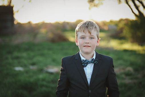 A portrait of a boy dressed up in a suit with blue bow ti