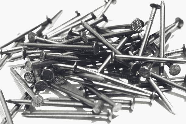 istock Closeup shot of metal nails on a white surface 1438581068