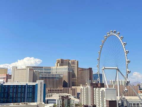 Las Vegas, United States – July 24, 2022: A scenic shot of the roller coaster surrounded by buildings against the sunny blue sky in Las Vegas, US