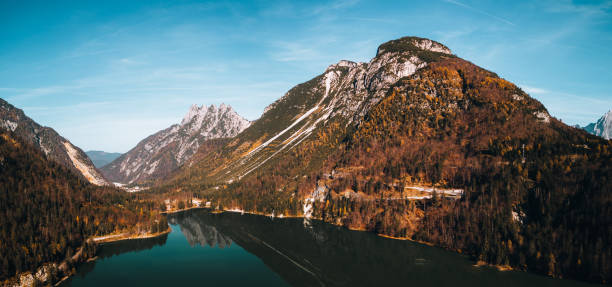 le lac predil ou raibler see est un lac de montagne verdoyant situé près de tarvisio, en autriche et en slovénie, dans les alpes juliennes. dans la vallée des pins à l’automne. - water surface european alps mountain valley photos et images de collection