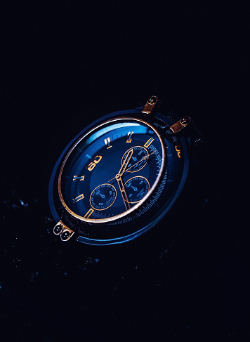 luxury blue men's watch with gold on a black background.