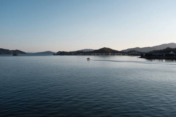 istock Sea surrounded by hills covered in buildings and greenery under a blue sky 1438582278