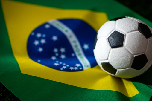 Brazil national football team. National Flag on green grass and soccer ball. Football wallpaper for Championship and Tournament in 2022. World international match.