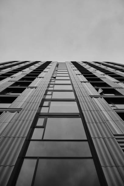 istock Low angle greyscale of a modern skyscraper under the cloudy sky 1438582596