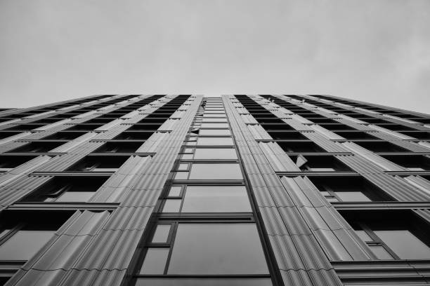 istock Low angle greyscale of a modern skyscraper under the cloudy sky 1438582623