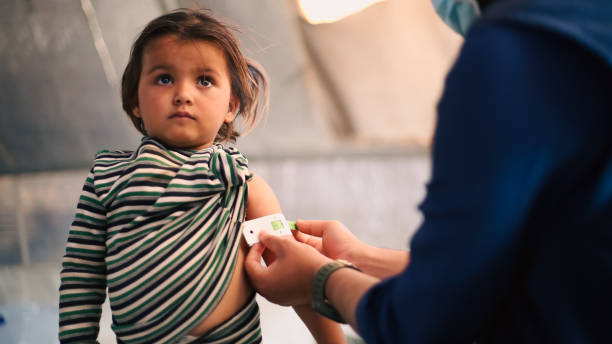 ein arzt untersucht die unterernährung von kindern in einem flüchtlingslager. - naher und mittlerer osten stock-fotos und bilder