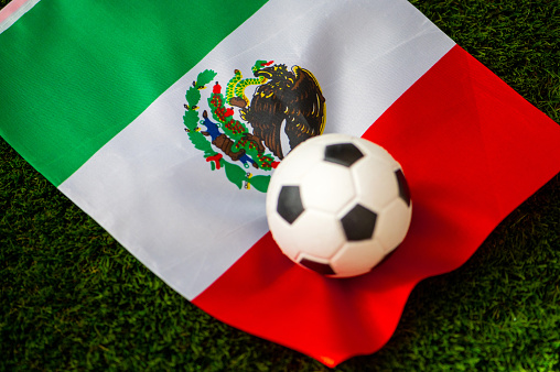 Mexico national football team. National Flag on green grass and soccer ball. Football wallpaper for Championship and Tournament in 2022. World international match.