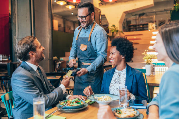 homem de negócios que paga com cartão de crédito - business meeting business lunch business person - fotografias e filmes do acervo