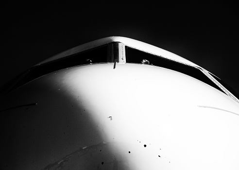 A grayscale shot of massive airplane with the head on and shadow