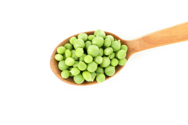 istock Spoon with pea seeds isolated on white background 1438587861