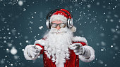 Cool Santa Claus is listening music in headphones