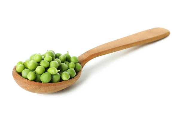 istock Spoon with pea seeds isolated on white background 1438588330
