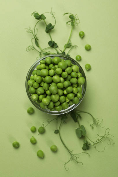 istock Bowl with pea seeds on green background 1438588474