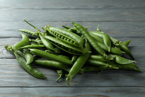 istock Fresh green pea on gray wooden table 1438588477