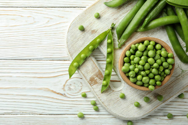 istock Fresh green pea on white wooden table 1438588598