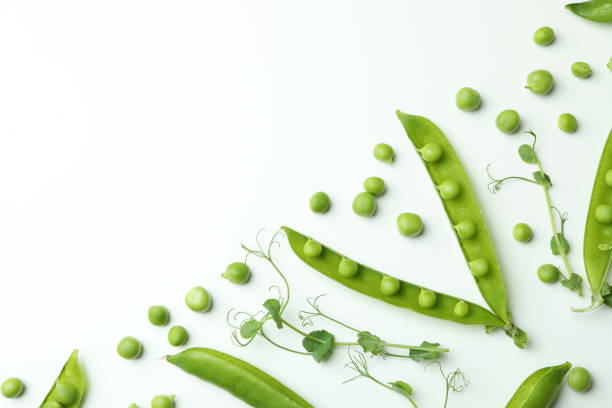 istock Green pea pods, seeds and twigs on white background 1438588829