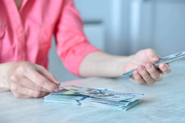 istock Woman holding dollars banknote in hand. 1438590190