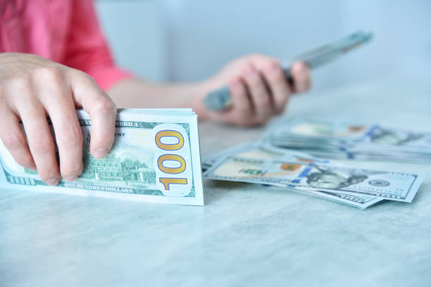 istock Woman counting dollars at table. 1438590245
