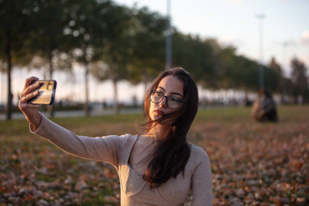 istock Beautiful brunette woman is taking selfie at sunset. 1438593043
