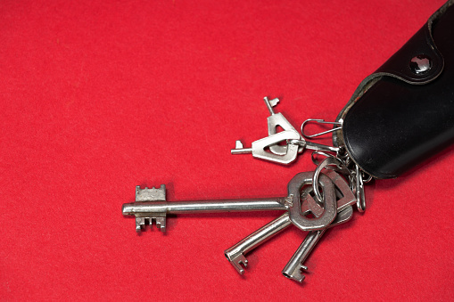 Vintage key holder and keys on red background with space for text.