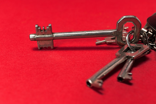 Vintage key holder and keys on red background with space for text.