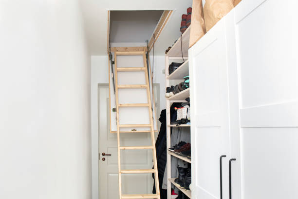 istock Wooden ceiling pull down attic folding stairs in small minimalist hallway corridor, space saving in home concept. 1438593746