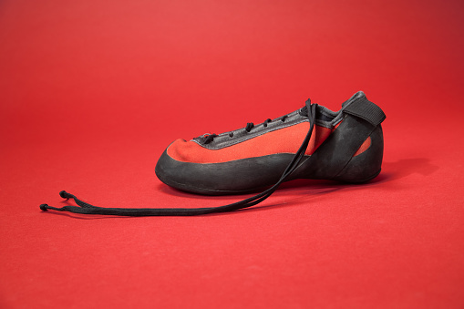 Climbing shoes isolated on red background.