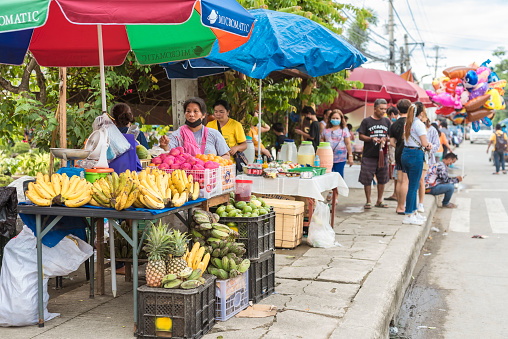 Tubigon, Bohol, Philippines - May 2022: A temporary fruit stand setup by the sidewalk during the town fiesta.