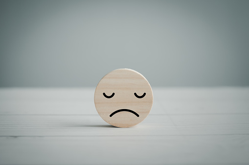 Unhappy face solitary on floor. Sadly, alone, insular, lonely. Emotion, Mental health assessment, World mental health day, Customer experience, Review, Feedback, Customer dissatisfaction client.