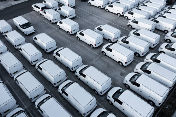 vista aérea directamente sobre una pila de nuevas furgonetas blancas listas para exportar e importar - fleet of vehicles fotografías e imágenes de stock