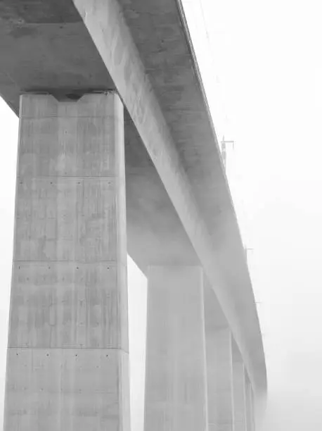 Photo of Minimalist image of a concrete bridge crossing the mist