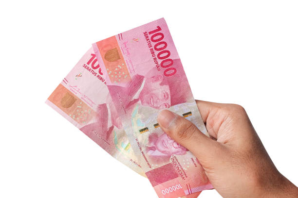 istock Hand holding one hundred thousand rupiah banknote isolated on a white background. financial concept 1438603281