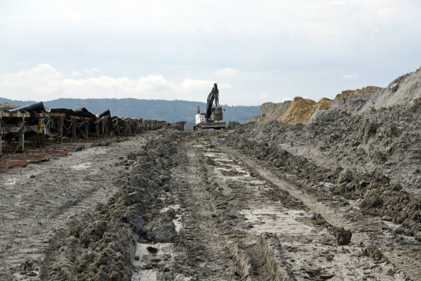 A bulldozer during operation on muddy ground in an open pit mine. Conveyor belt on surface coal mine.