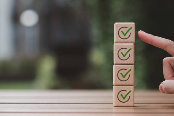 istock Checklist, Task list, Survey and assessment, Quality Control, Goals achievement and business success. Elections and Voting, Vote, to do list, Hand point to green check mark on top of wooden stack. 1438606550