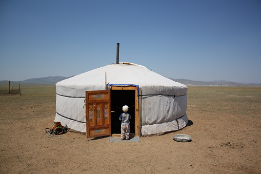 A boy in front a nomadic tent (ger), Atar sum in Tuv province, Mongolia. The children always enjoy their time outdoors around the solitary steppes any time. Some nomadic families live in the surrounding steppes.