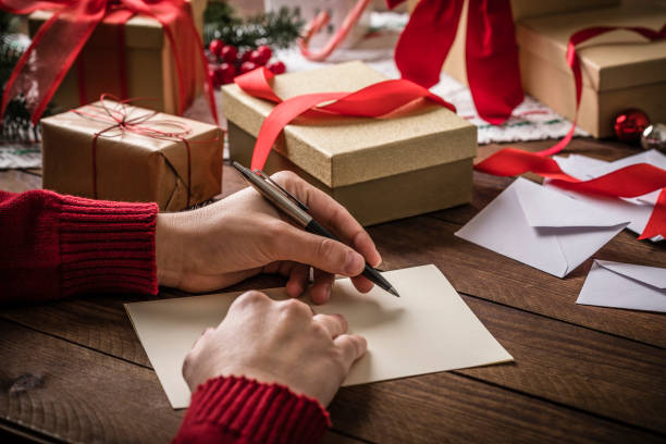 un jeune homme écrit une carte de noël - index card photos et images de collection