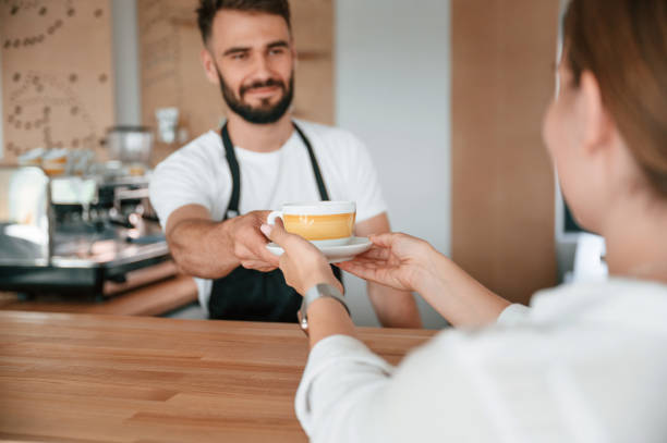 istock Customer takes her order from barista in the cafe 1438608508