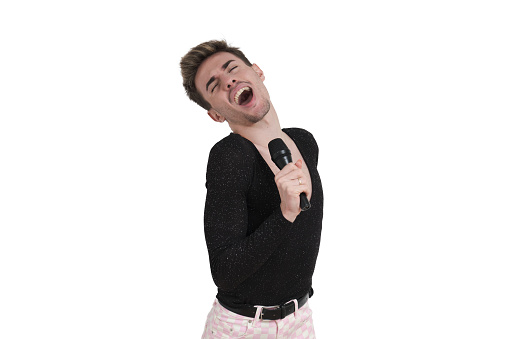 Young caucasian man singing with a microphone. Isolated over white background.