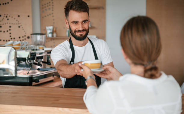 istock Customer takes her order from barista in the cafe 1438608604