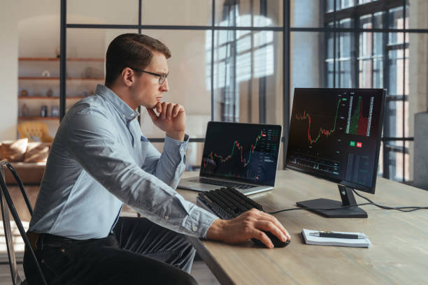 istock Trader analyst at office analyzing indexes, financial chart, trading online at his PC 1438609735