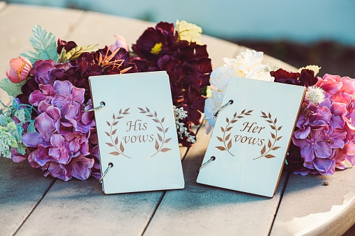 Toma de enfoque selectivo de votos matrimoniales colocados junto a hermosas flores photo