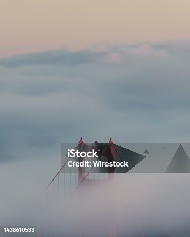 istock Vertical shot of the golden gate bridge surrounded by clouds 1438610533