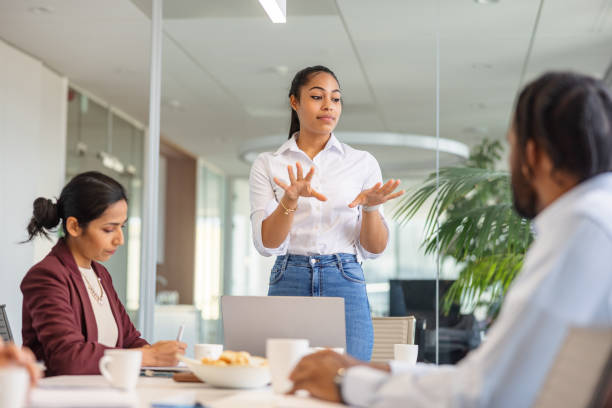 istock Young African-American Explaining And Looking To Her Colleagues 1438610777